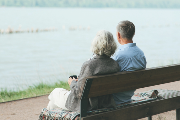 Retired couple relaxing outdoors, symbolizing financial security through inflation-protected strategies and healthcare planning.