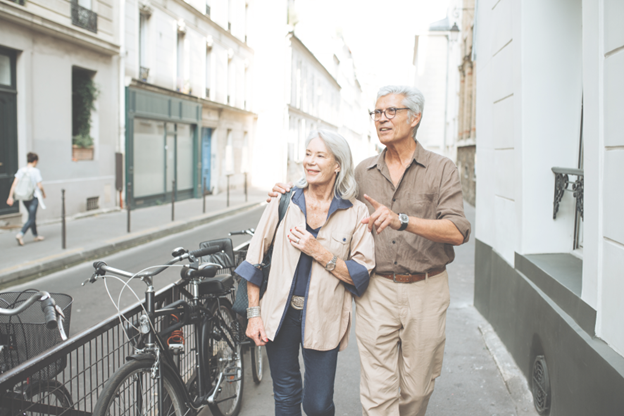 Smiling retired couple walking outdoors, representing the financial freedom and tax-free retirement income benefits of an IUL life insurance policy